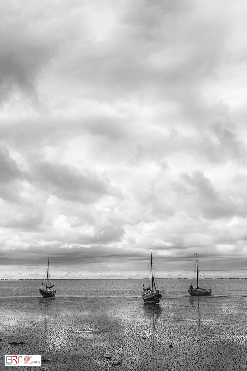 3 boten op het drooggevallen wad