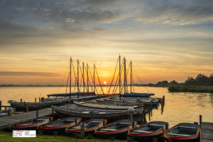 Leekstermeer met boten aan de steiger tijdens zonsopkomst