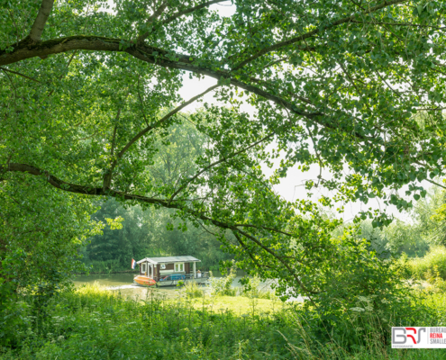 Blokboot op de Linge omrand met bomen