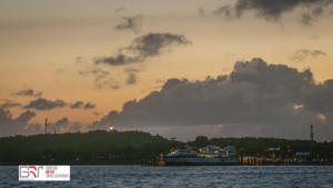 Zicht op vuurtoren en snelboot in de haven van Vlieland tna zonsondergng